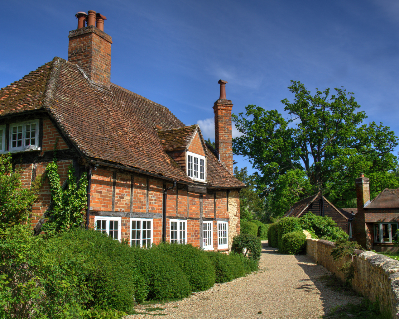Кирпичный старый дом под голубым небом, Англия 