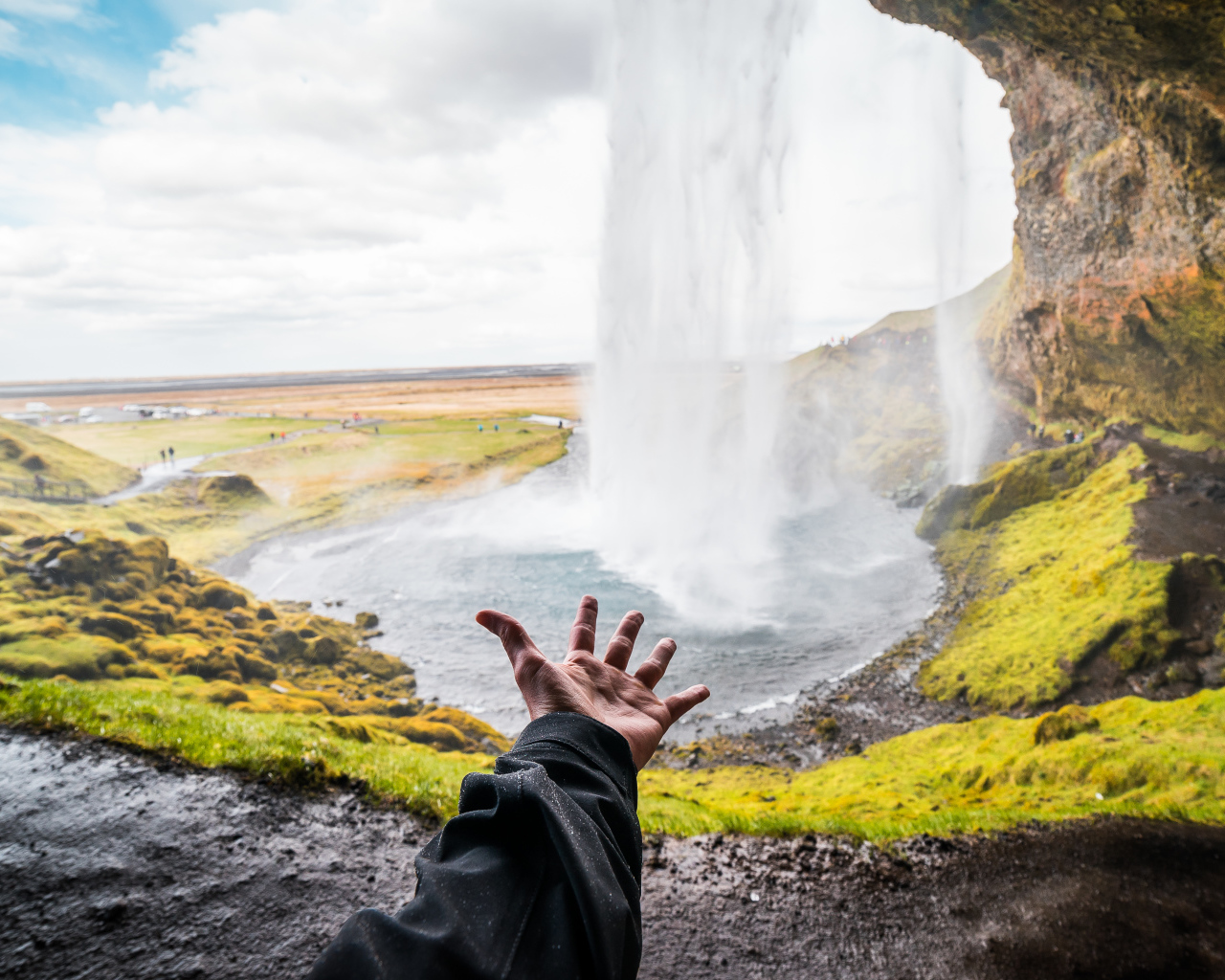 Рука тянется к водопаду Сельяландсфосс, Исландия