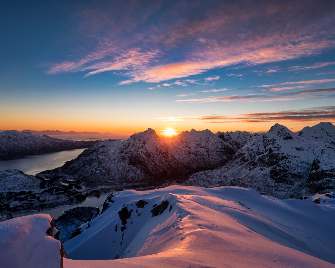 Красивый вид на заснеженные горы в лучах солнца на рассвете, Норвегия