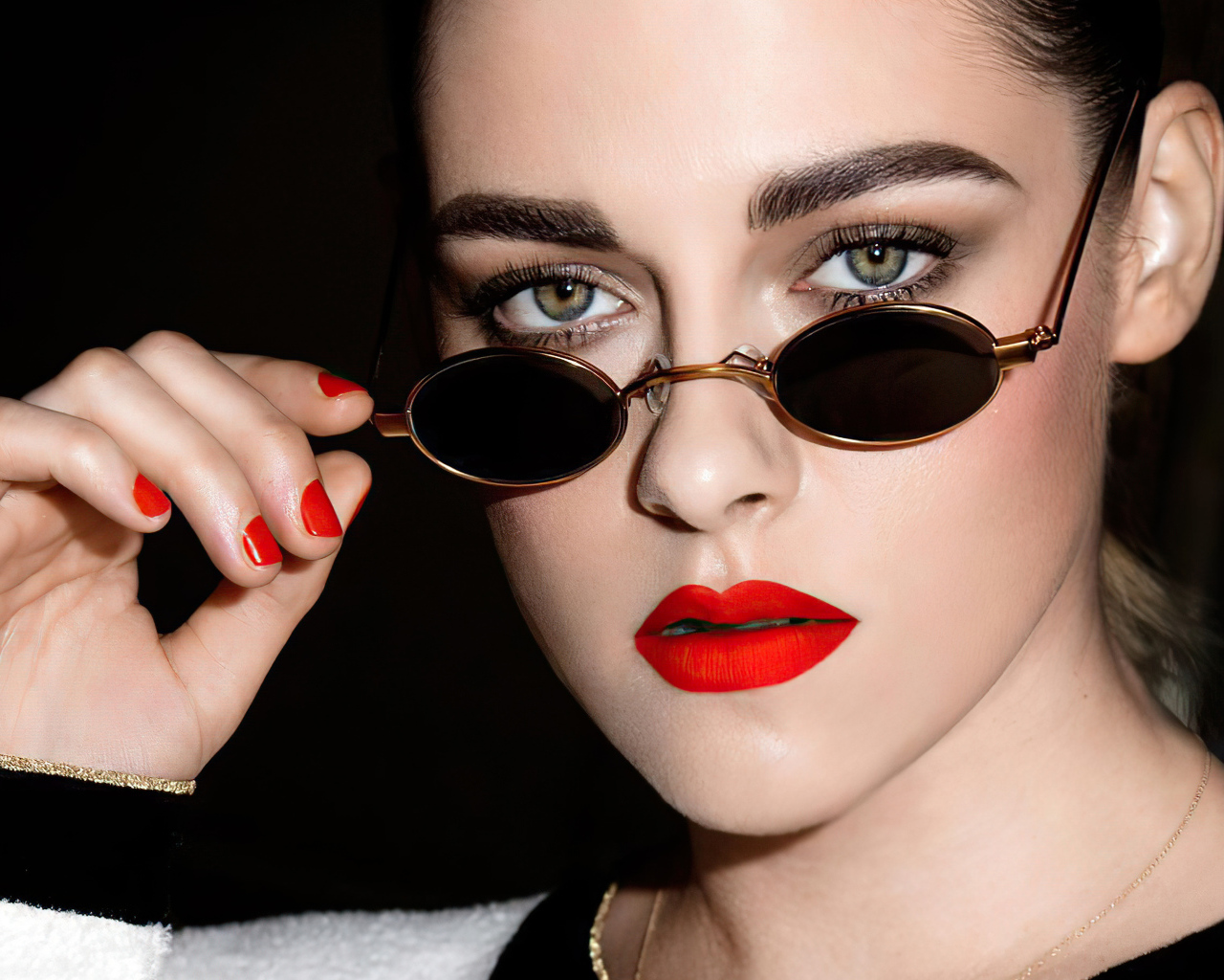 Актриса Кристен Стюарт в очках на  черном фоне