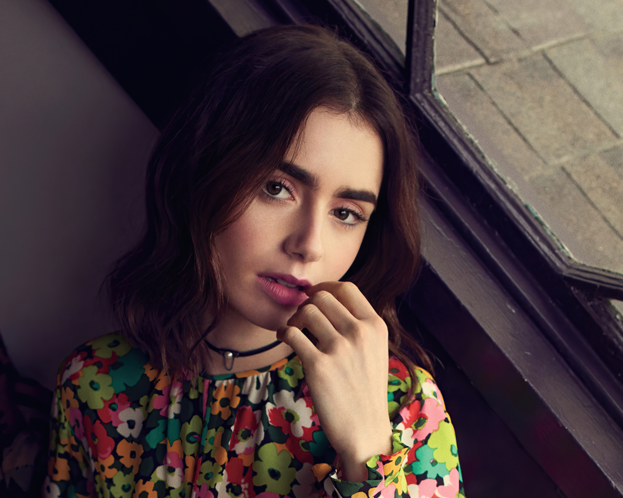 Актриса Лили Коллинз сидит у окна