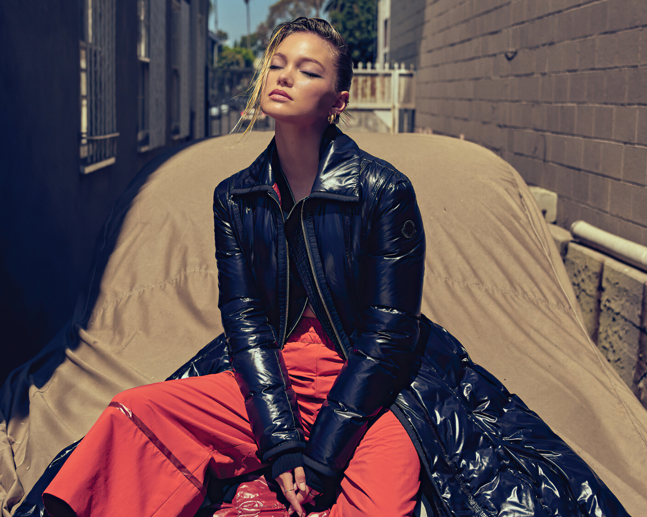 Актриса Оливия Холт в черной куртке сидит на машине