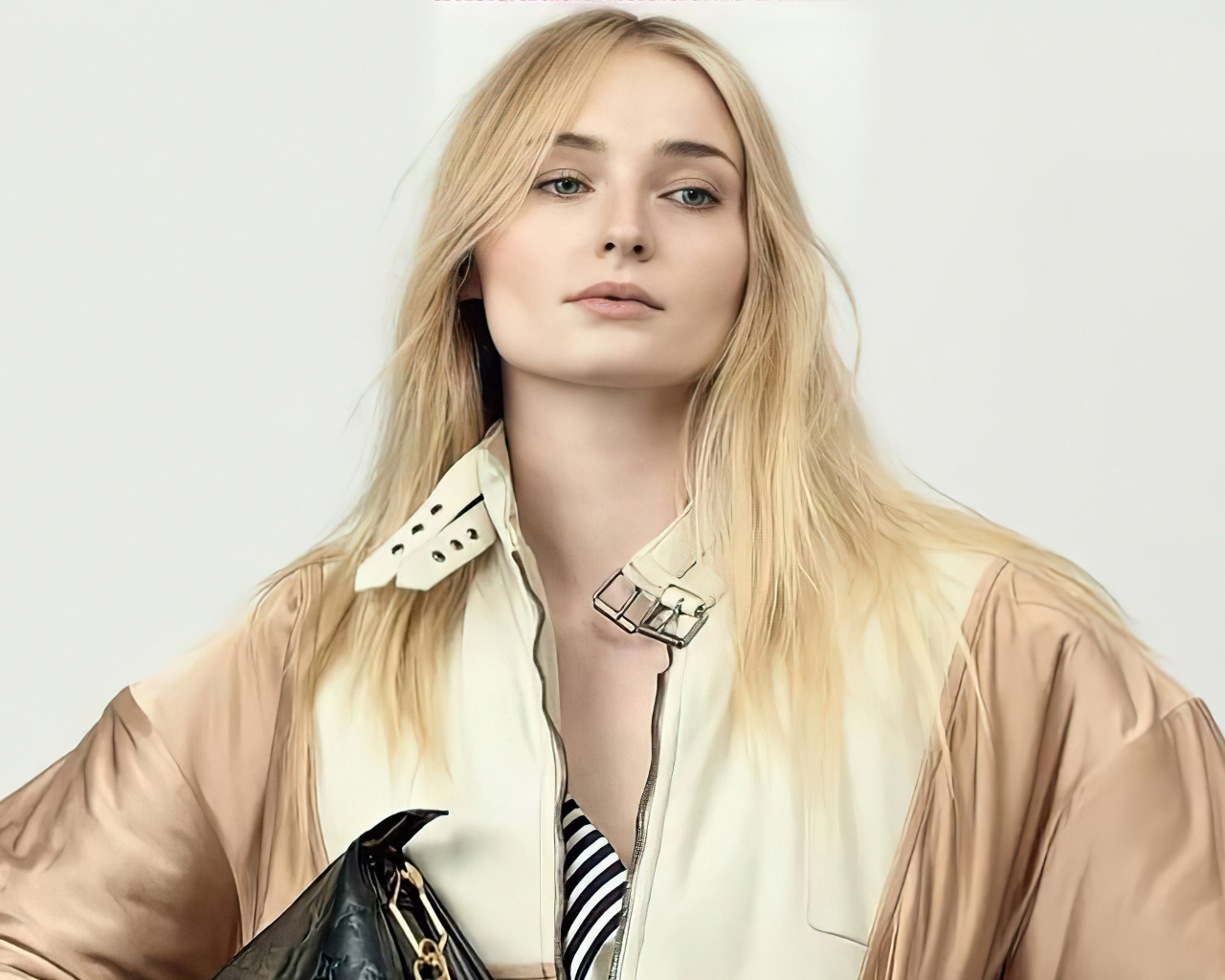 Актриса Софи Тёрнер в куртке на белом фоне