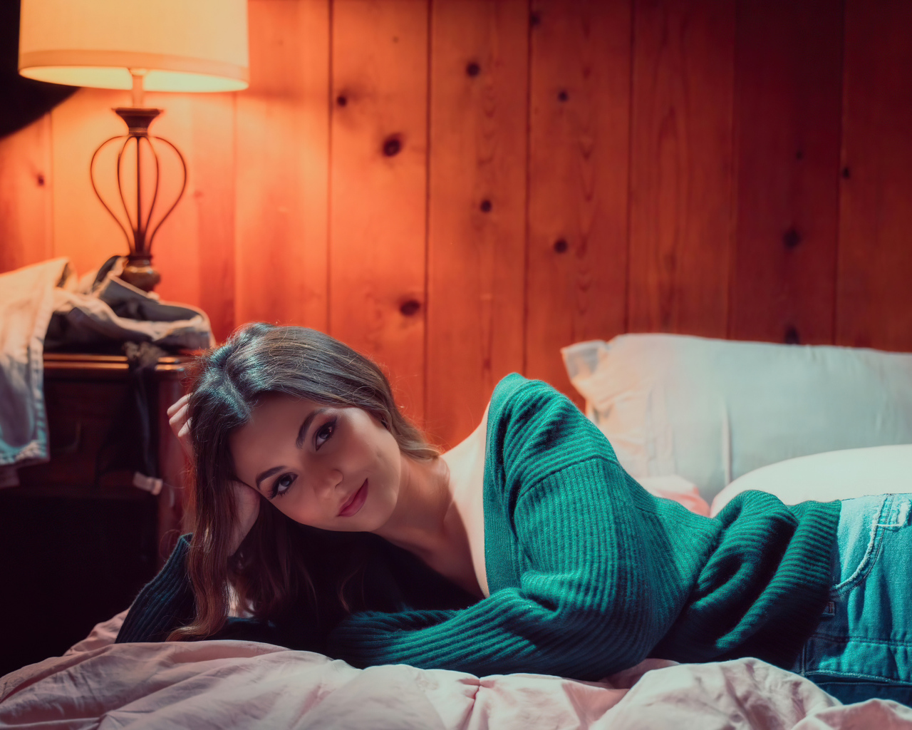 Актриса  Виктория Джастис в зеленом свитере на кровати