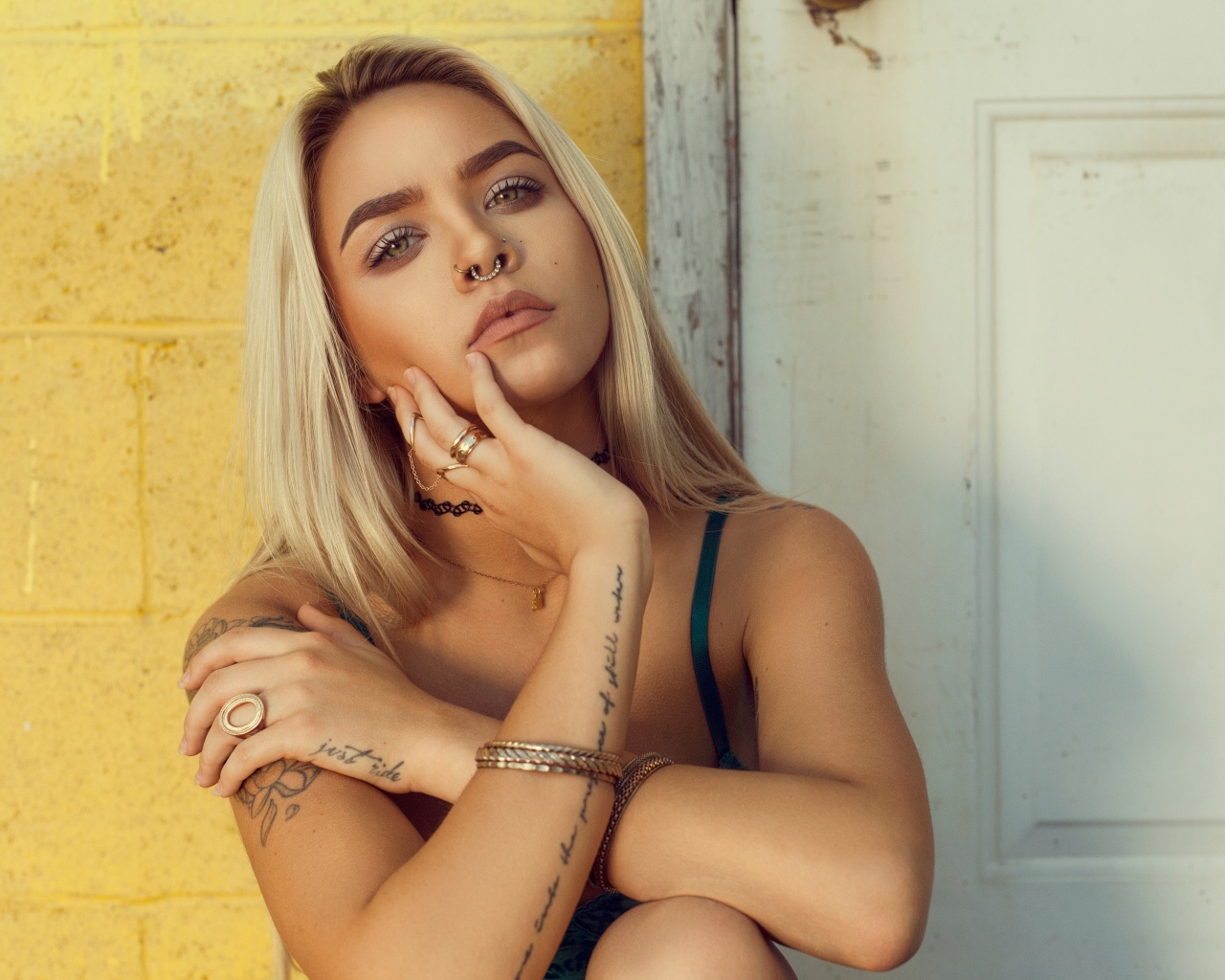 Красивая девушка в татуировках с пирсингом в носу 