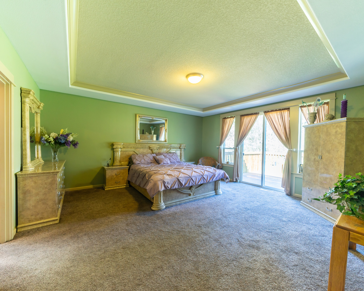 Красивая большая спальня с зелеными стенами 