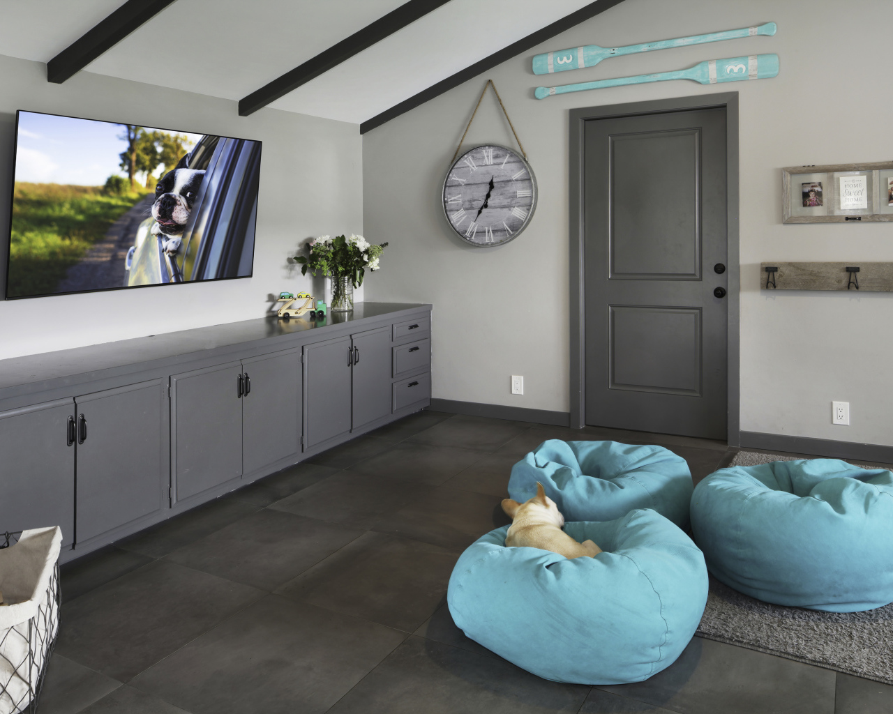 Голубые кресла в комнате с большим телевизором 