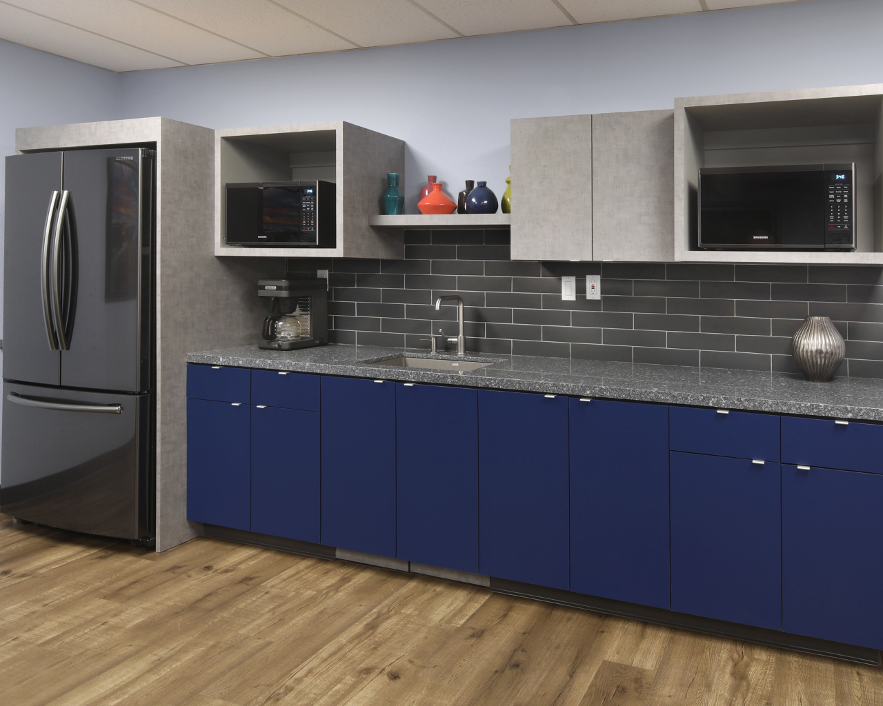 Синие шкафы и большой холодильник на кухне