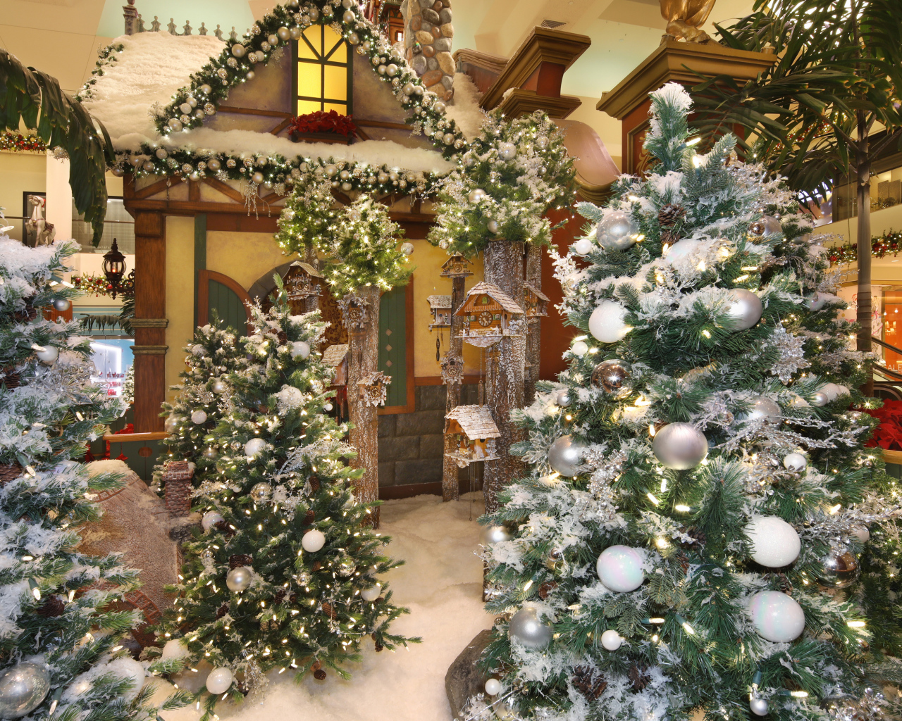 Новогодние ели стоят в комнате с декором 