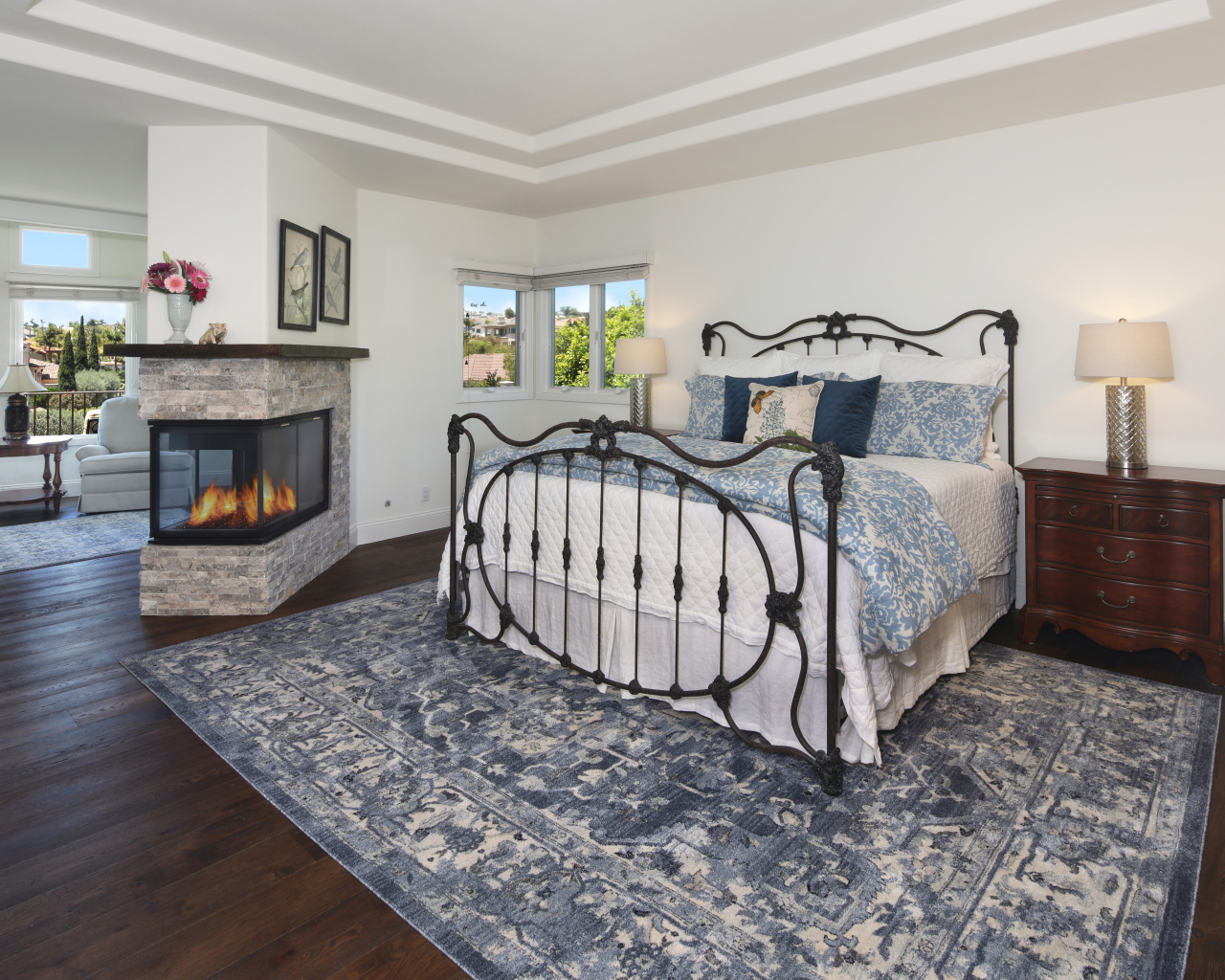 Уютная спальная комната с камином и большой кроватью