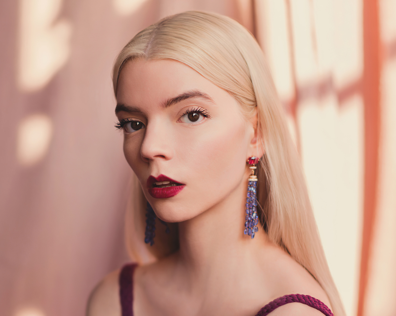 Милая блондинка, актриса Аня Тейлор-Джой на розовом фоне