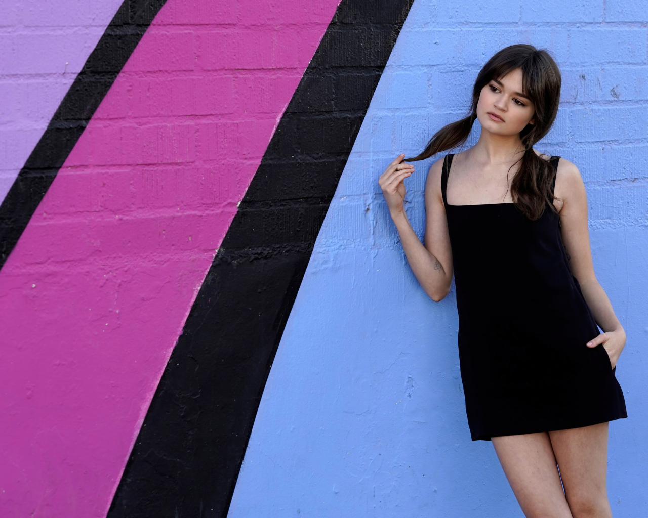 Милая девушка актриса Сиэра Браво у разноцветной стены