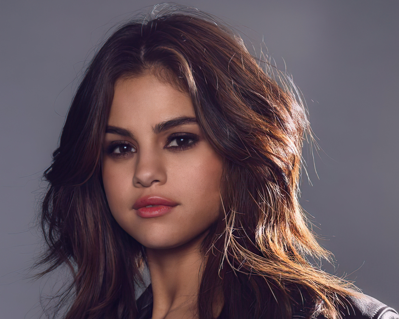 Лицо молодой девушки  Селены Гомез на сером фоне