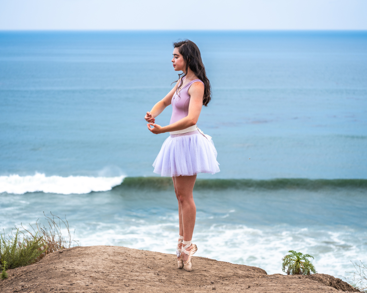 Девушка балерина занимается на берегу океана