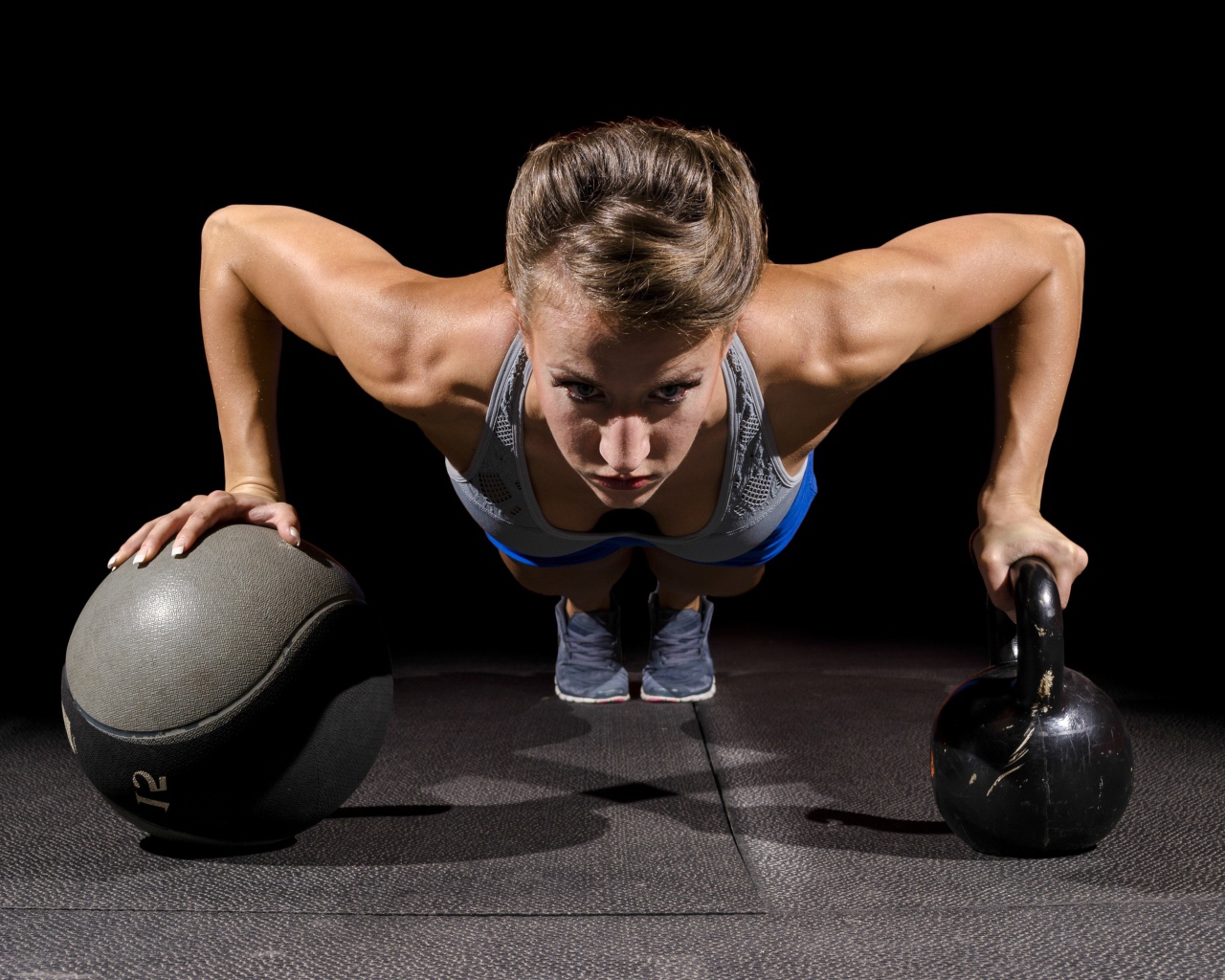 Девушка отжимается с гирями