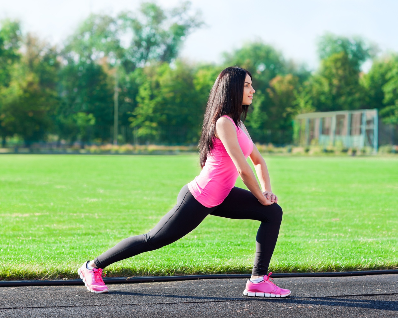 Девушка делает растяжку на поле 