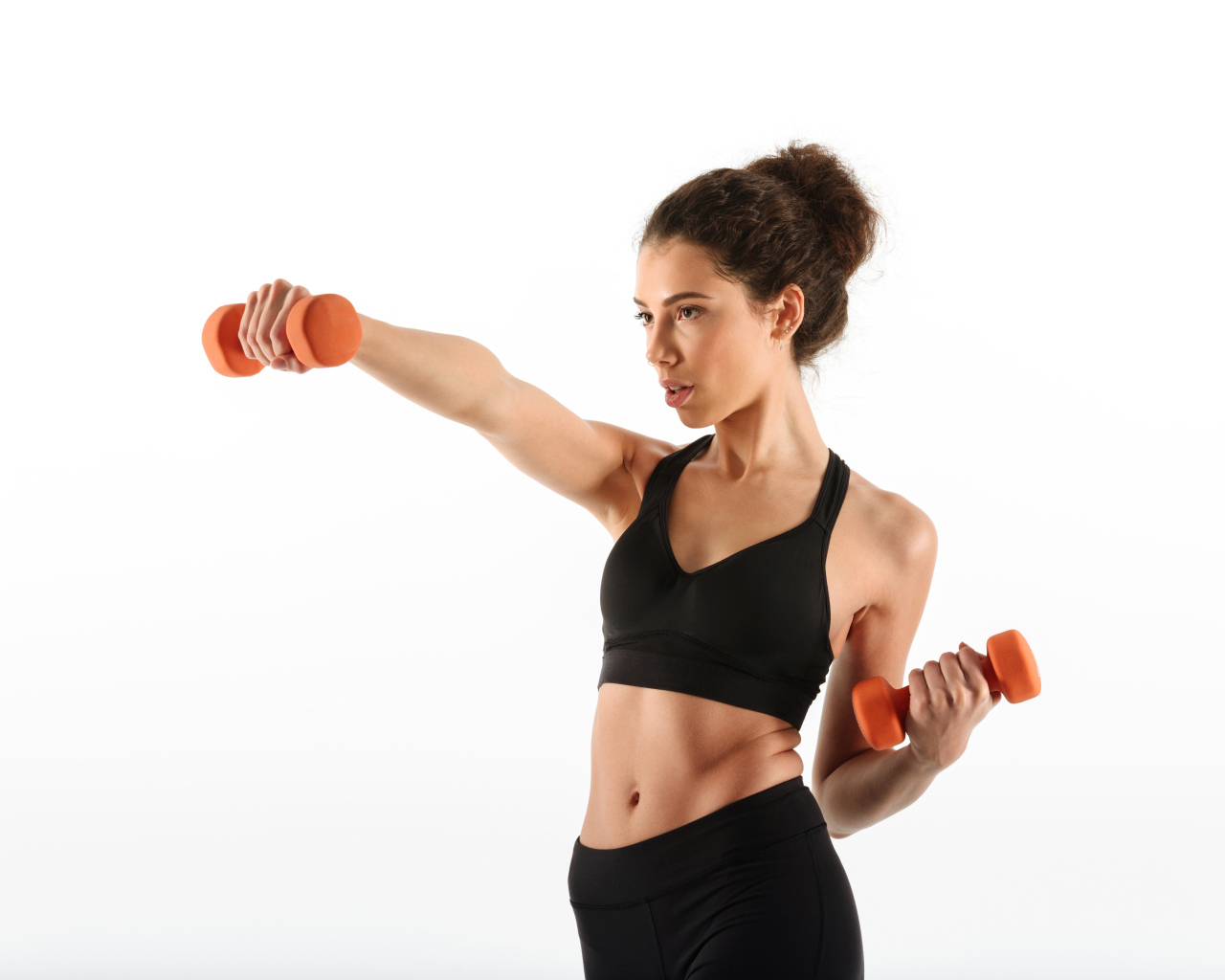 Девушка качает руки гантелями на белом фоне