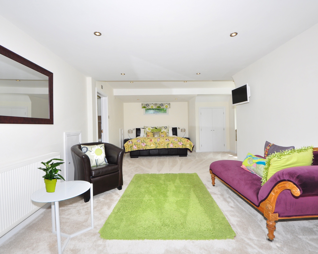 Большая гостиная с высокими белыми стенами и мебелью 