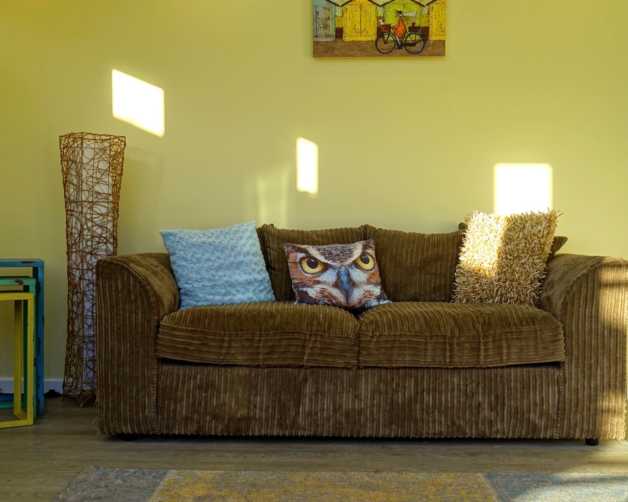 Большой старый диван в комнате с желтыми стенами