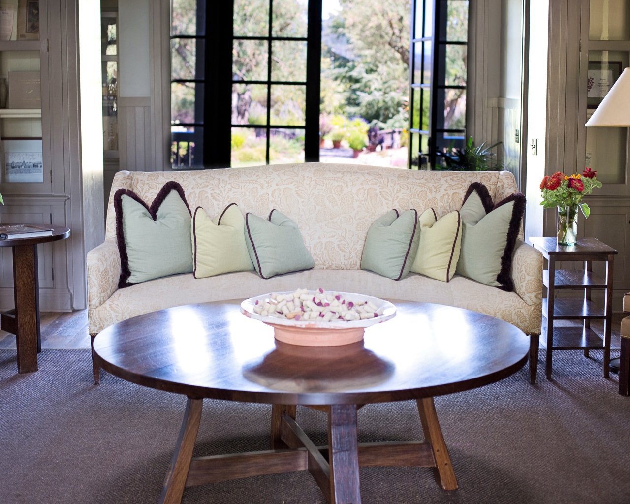 Большой диван с подушками в комнате с круглым столом 