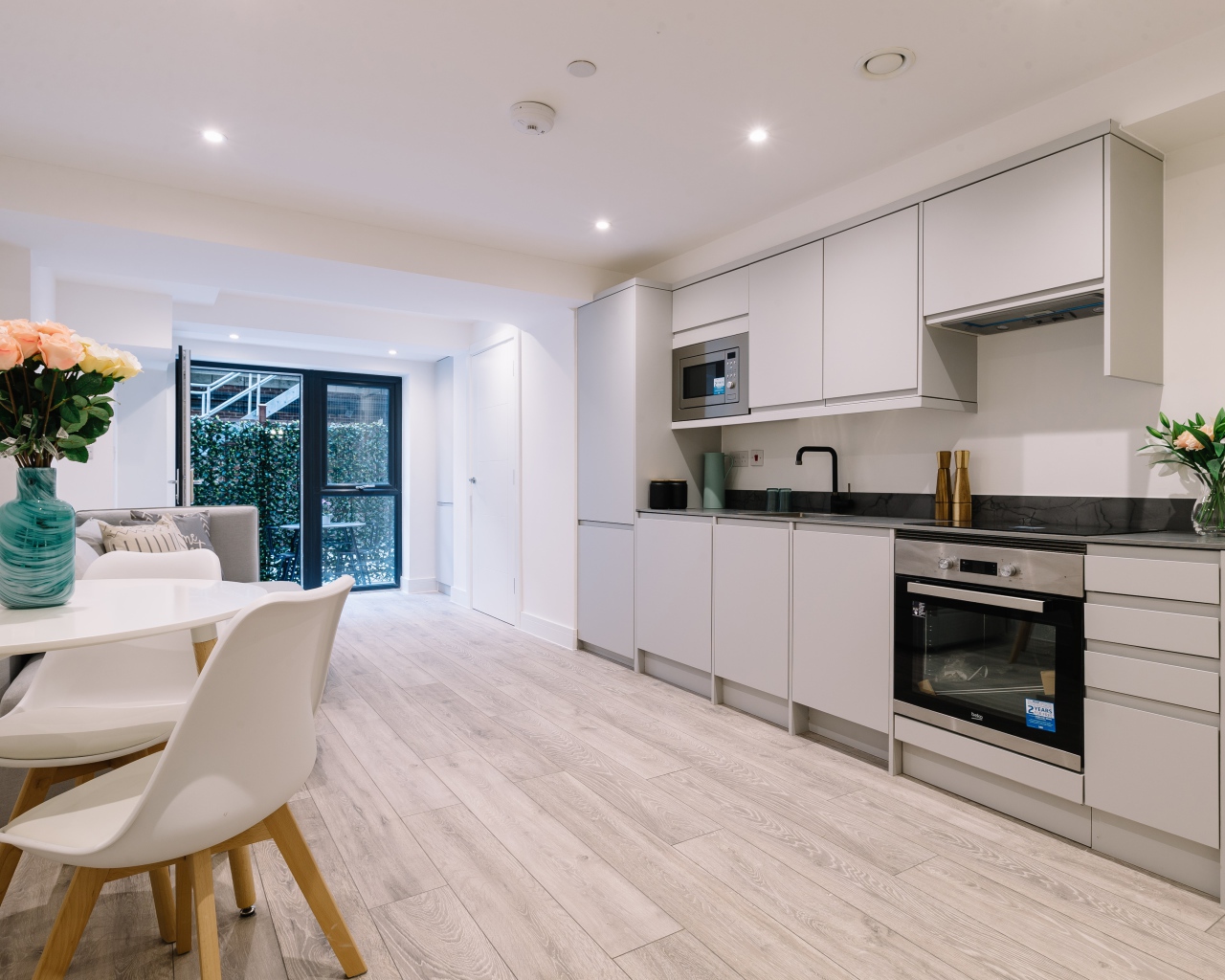 Большая просторная белая гостиная с букетом роз