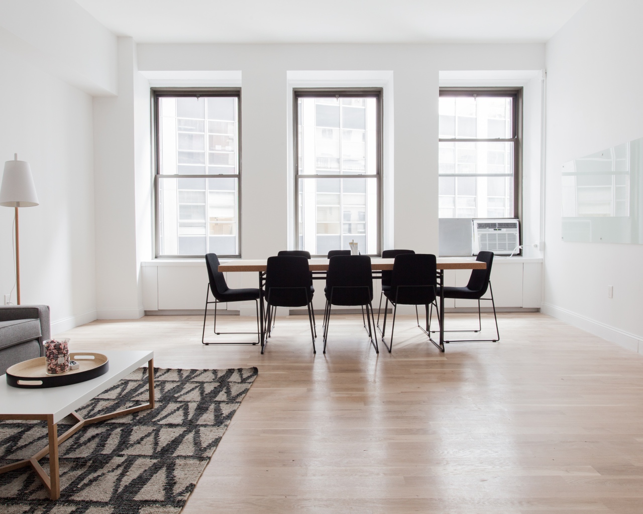 Большой стол с черными стульями в гостиной у окна 