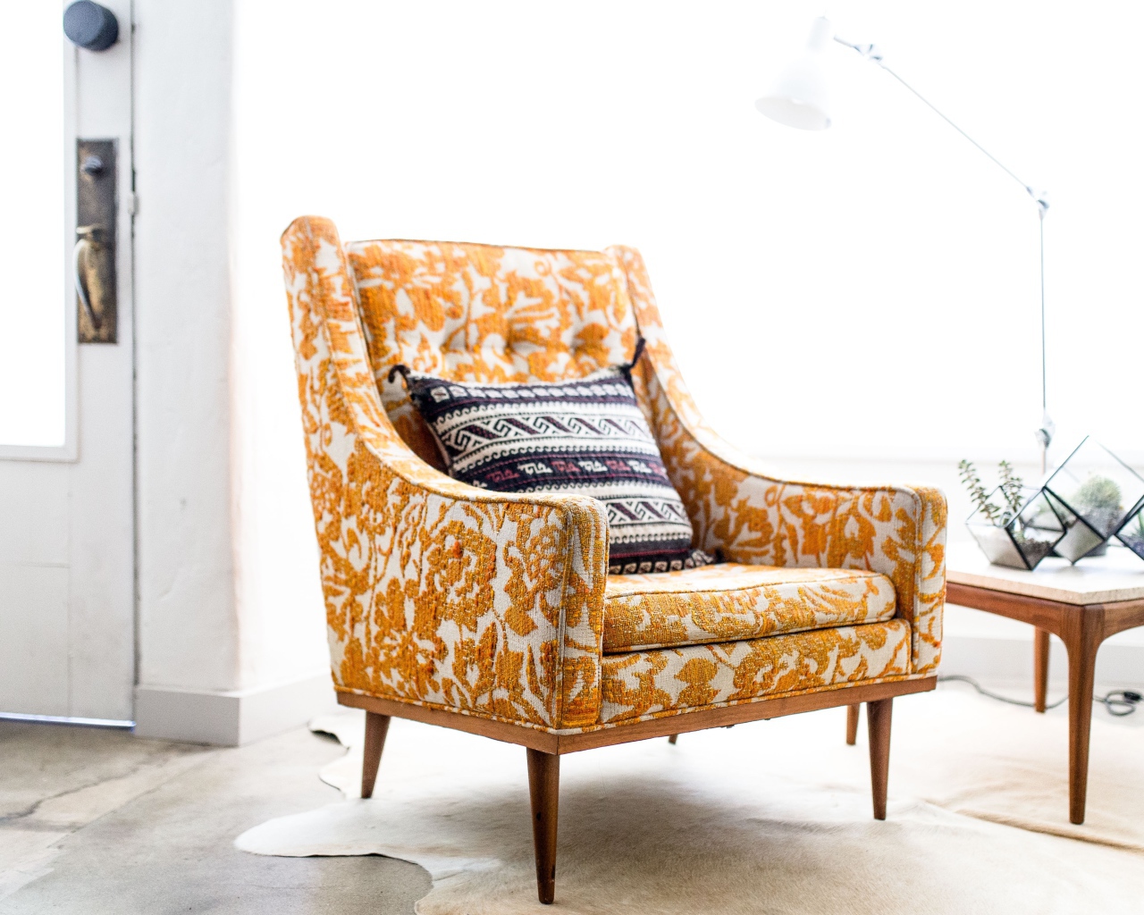 Старое кресло с подушкой в комнате 