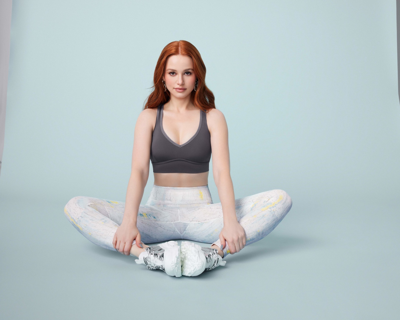 Рыжеволосая американская актриса Мэделин Петш сидит в позе лотоса