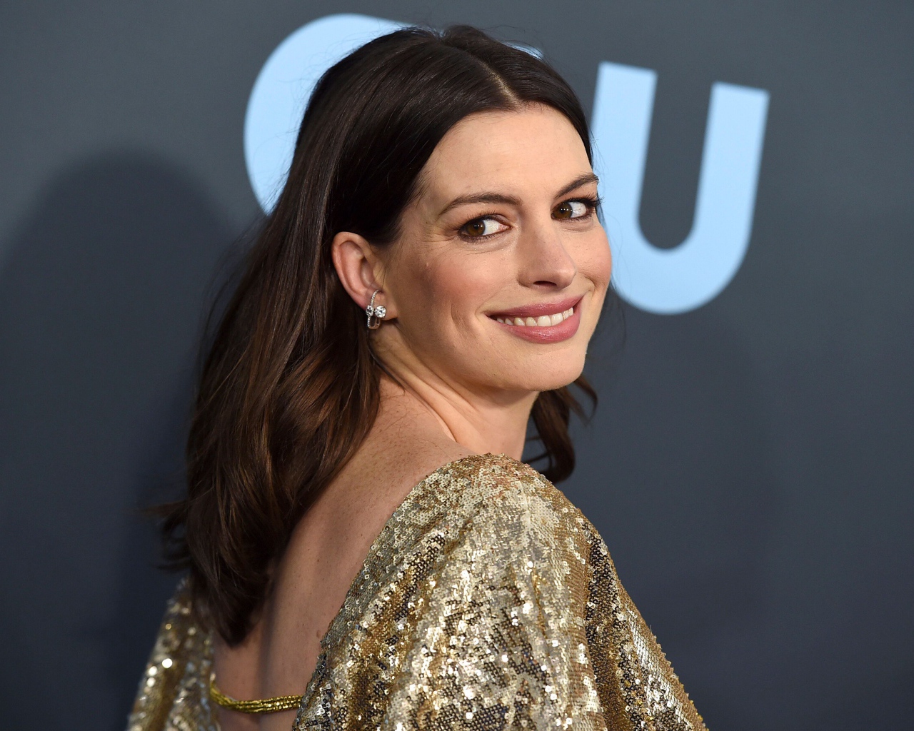 Smiling actress Anne Hathaway in a bright dress