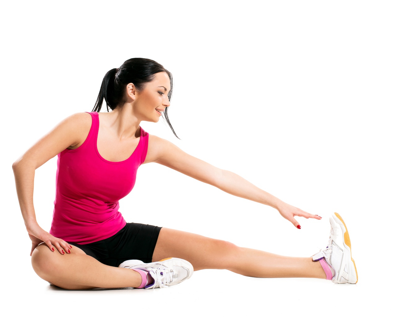 Спортивная девушка делает растяжку на белом фоне 
