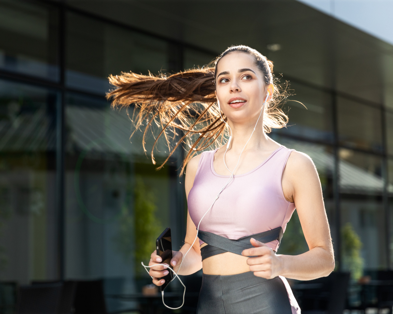 Спортивная девушка занимается бегом на улице