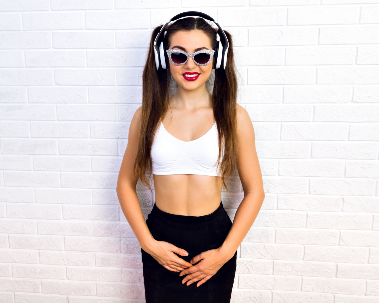 Спортивная девушка в очках у стены