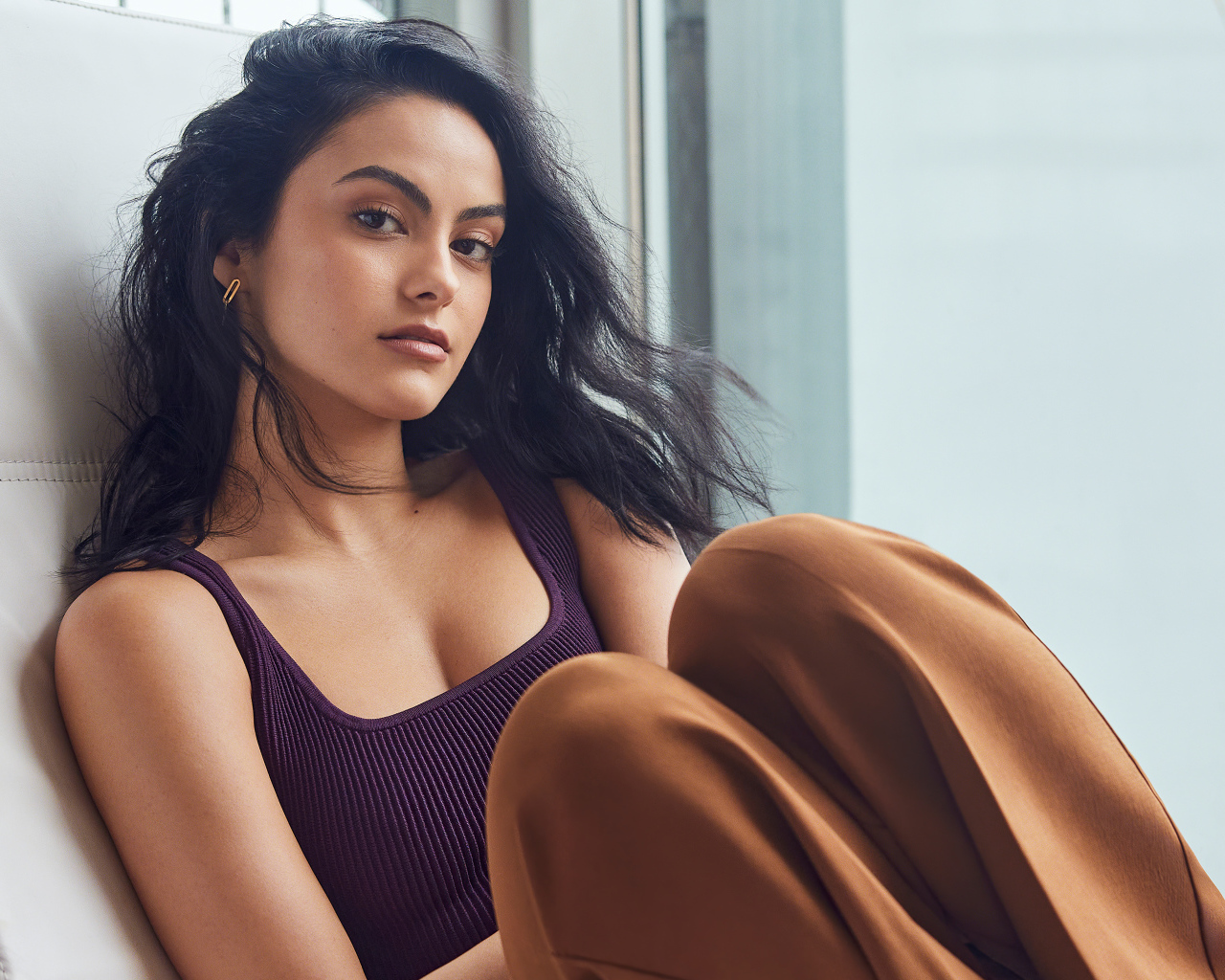 Стильная брюнетка Камила Мендес сидит на кресле