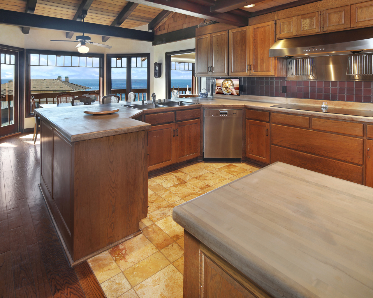Деревянная мебель на кухне с окнами с видом на море