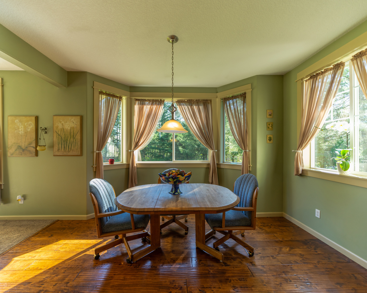 Деревянный стол стоит в гостиной с зелеными стенами