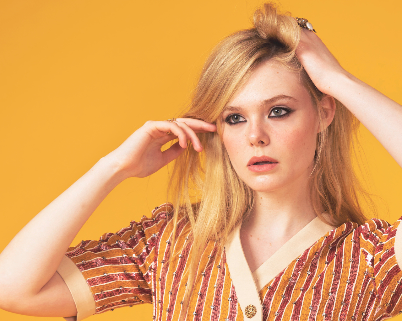 Молодая американская актриса Эль Фэннинг на желтом фоне