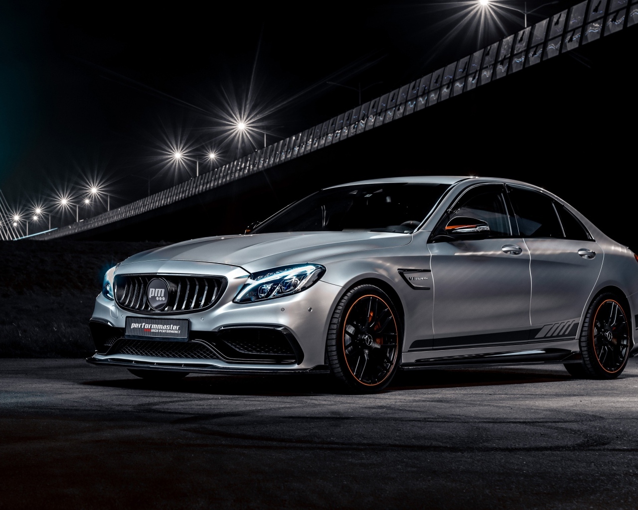 Серебристый автомобиль Performmaster C 63 V8 под мостом