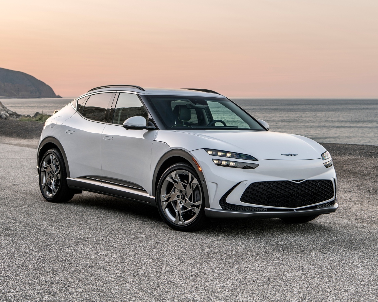 Белый автомобиль Genesis GV60, 2023 года на пляже