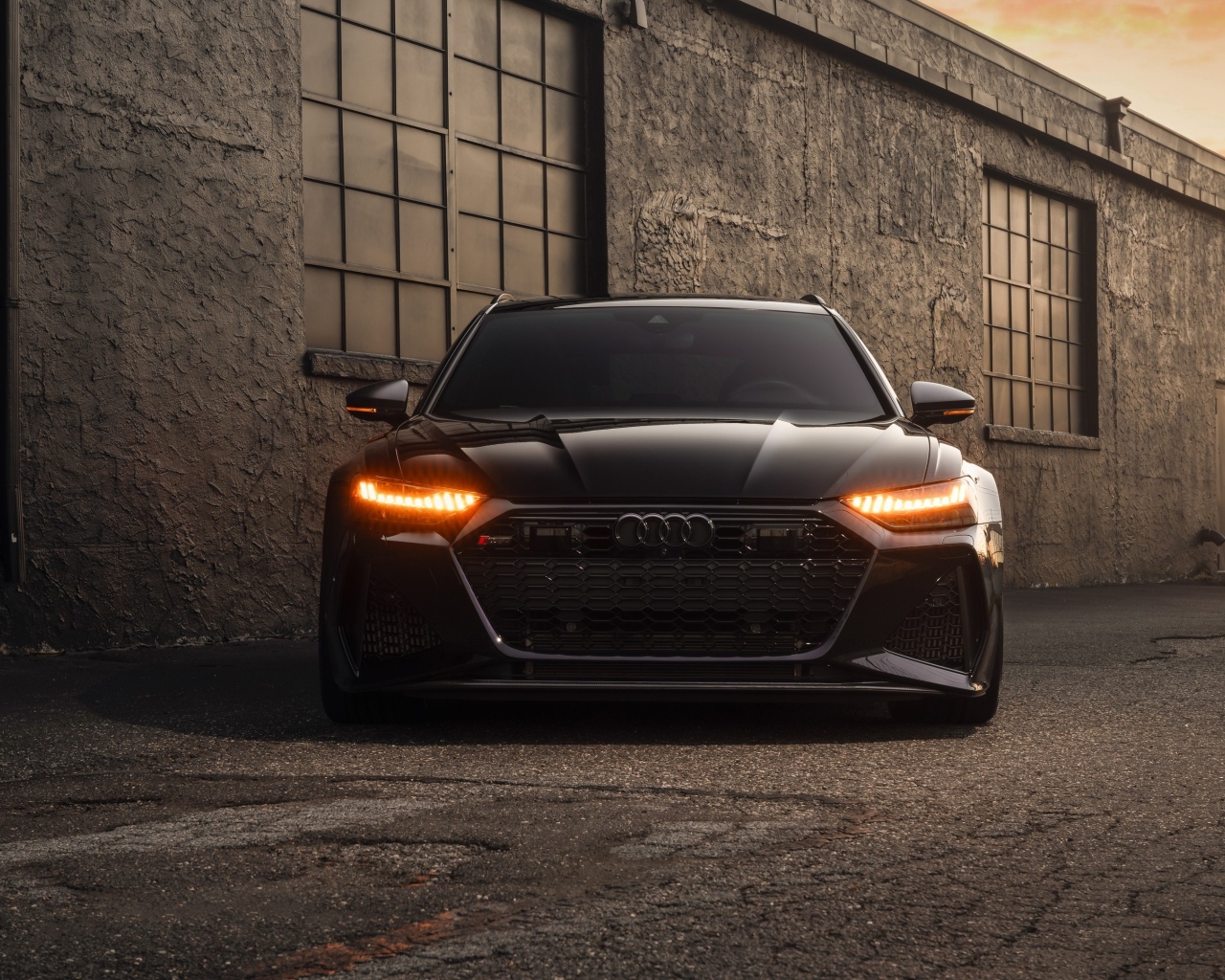 Черный автомобиль Audi RS7 у стены