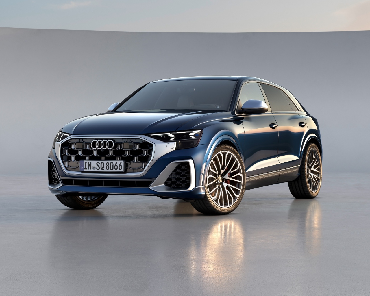 Синий автомобиль Audi SQ8 TFSI 2023 года на сером фоне