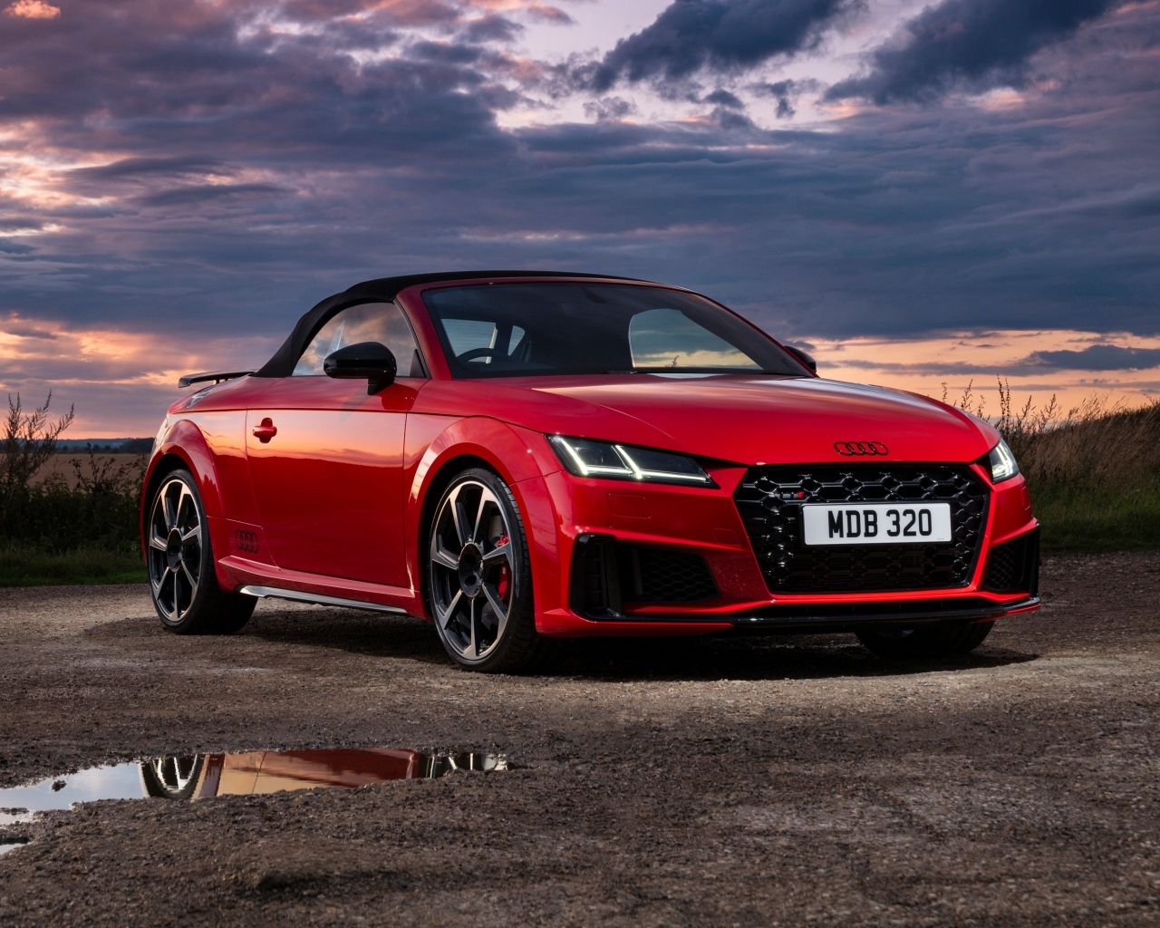 Красный автомобиль Audi TTS Final Edition Roadster 2023 года на фоне неба