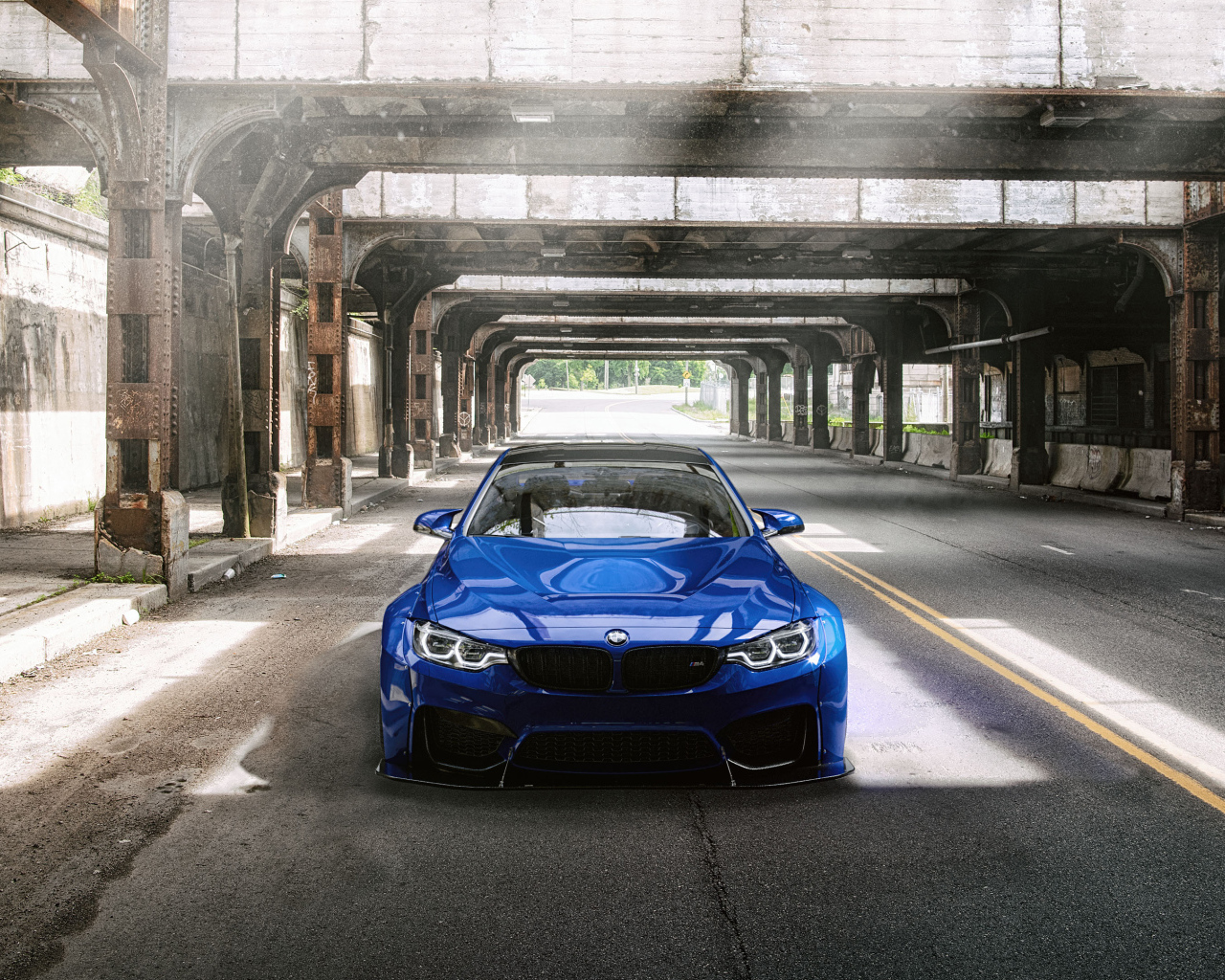 Синий автомобиль BMW M4 под мостом