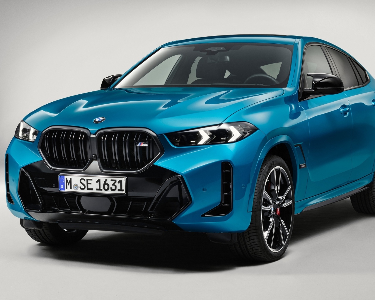Автомобиль  BMW X6 2023 вид спереди на сером фоне