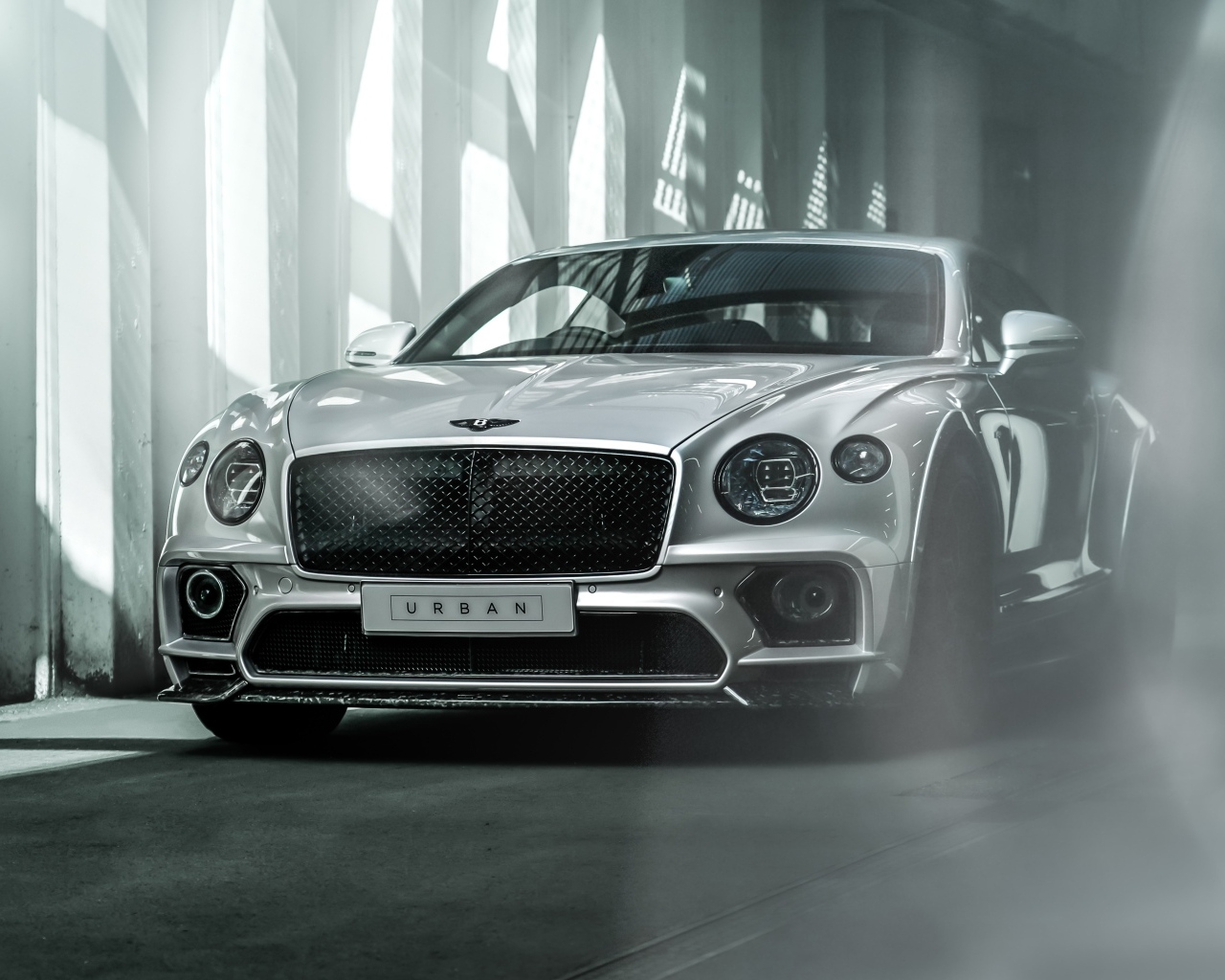 Серебристый автомобиль Bentley Continental GT в здании