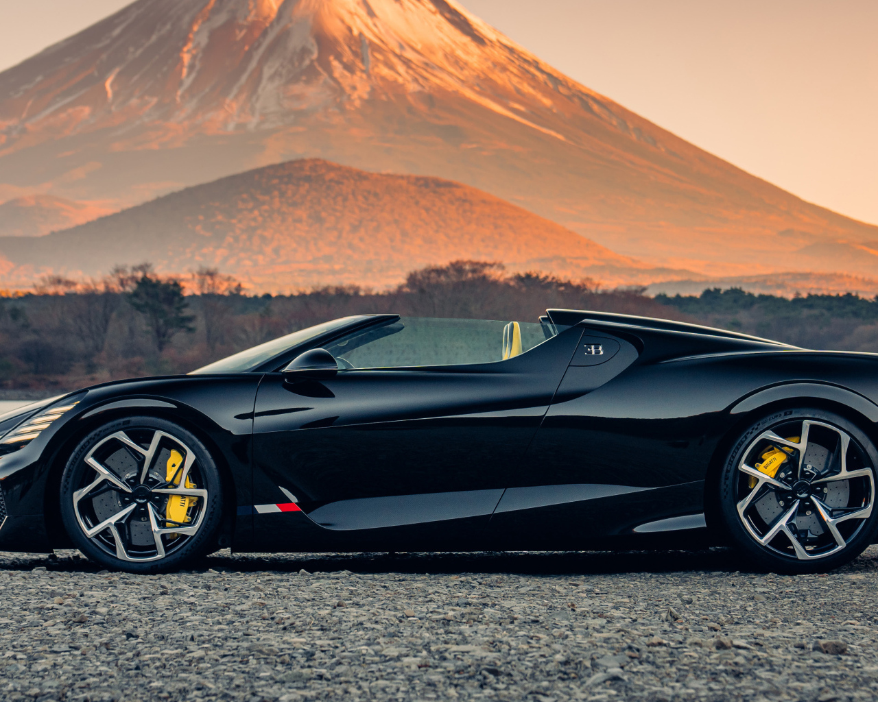 Черный автомобиль Bugatti W16 Mistral  на фоне горы