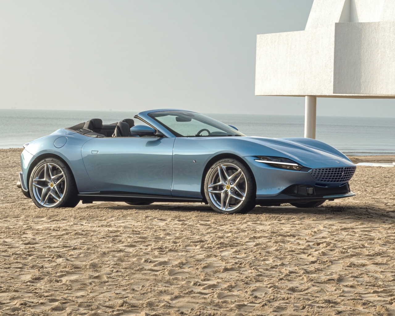 Автомобиль Ferrari Roma Spider 2023 года стоит на песке