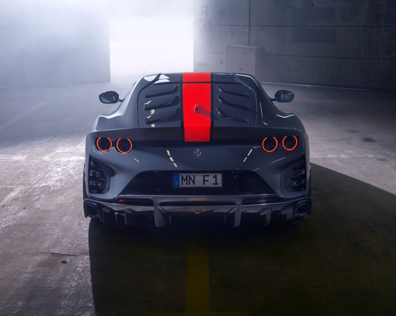 Серый спортивный автомобиль Ferrari 812 вид сзади