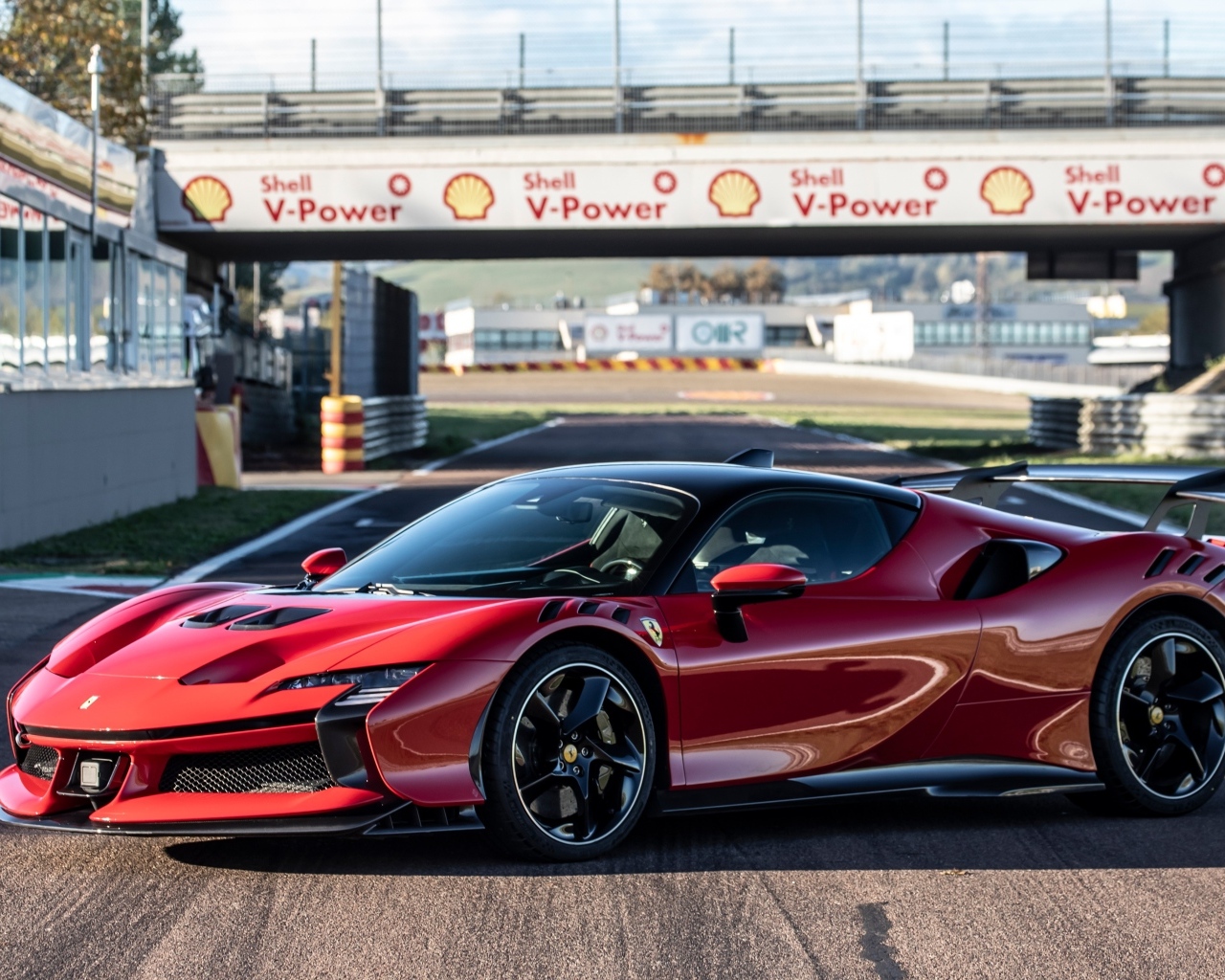 Красный автомобиль Ferrari SF90 XX Stradale на стадионе