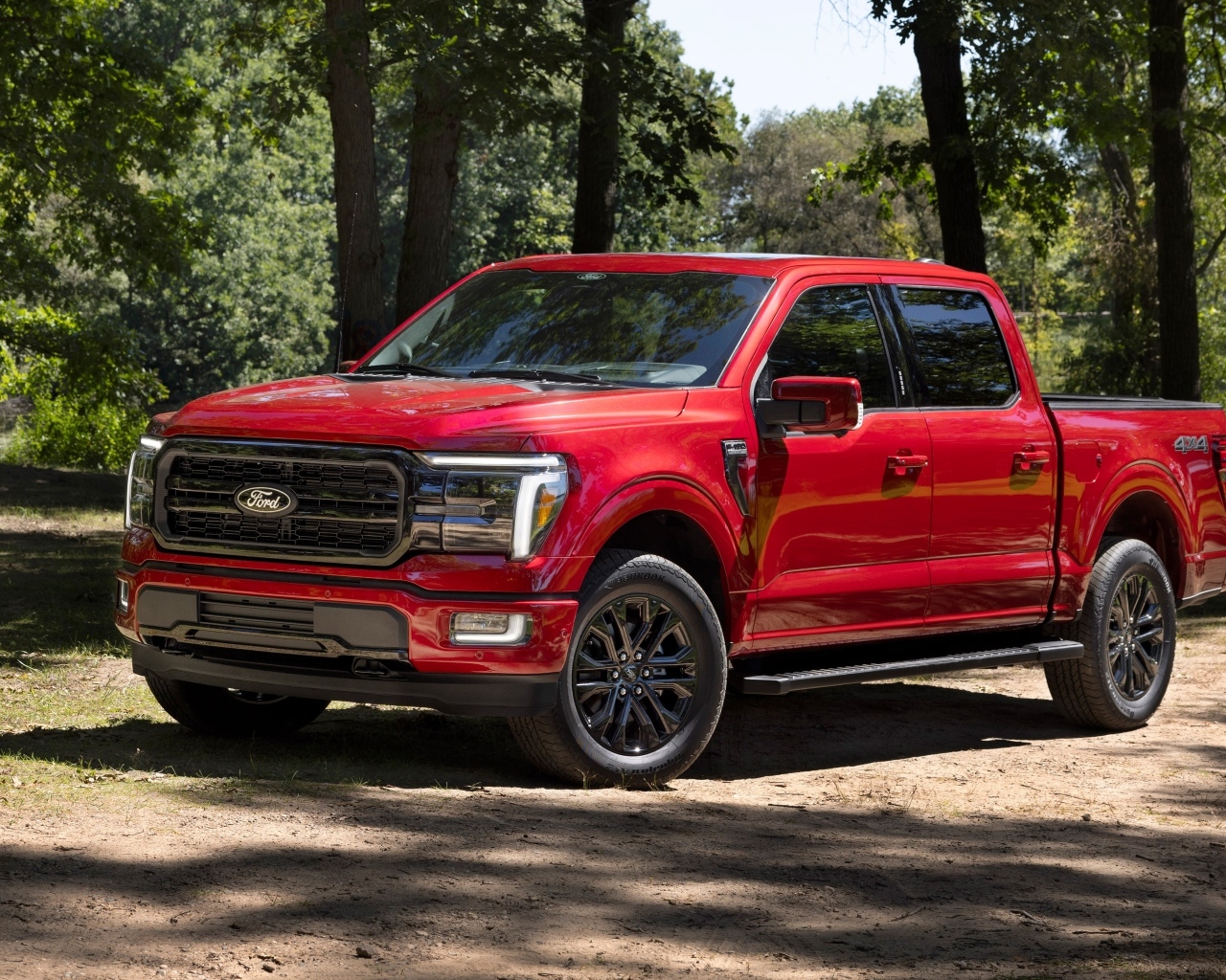 Большой красный Ford F-150 Lariat 2024 года в лесу