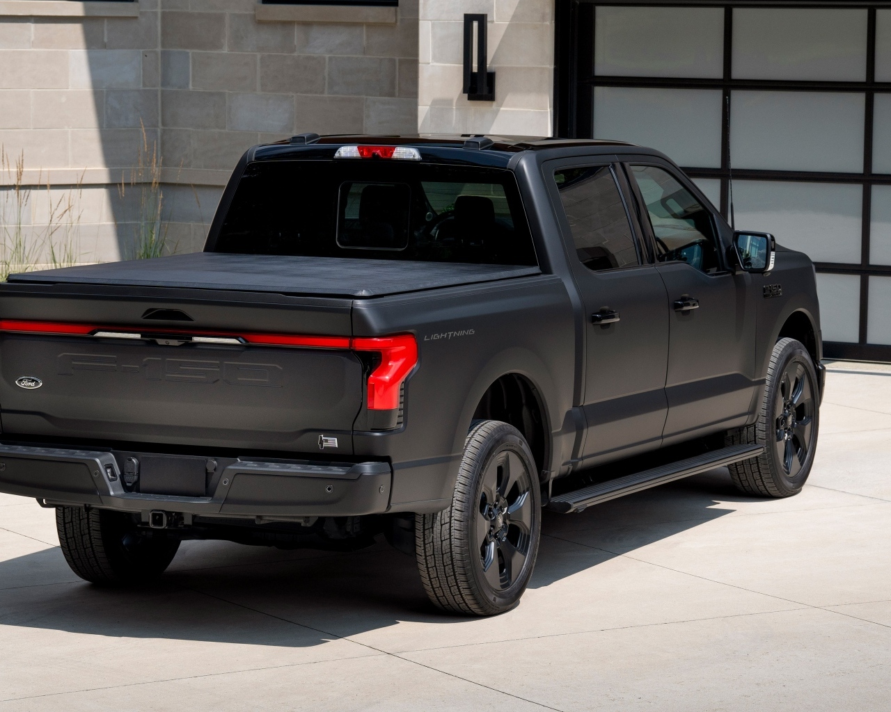 Черный пикап Ford F-150, 2024 года стоит у гаража